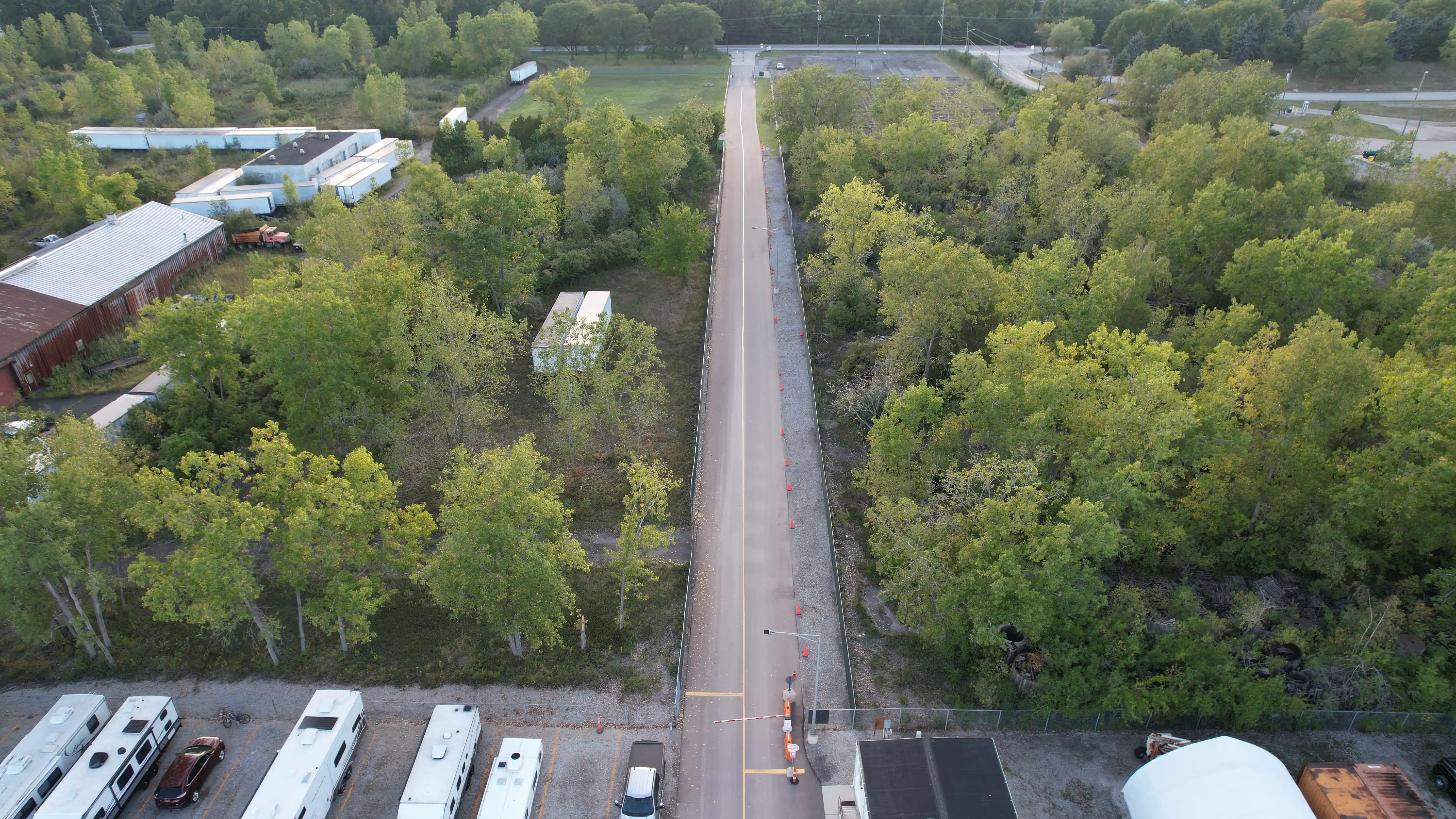 Paved, tree-lined entrance drive leading into the gated Star Storage facility
